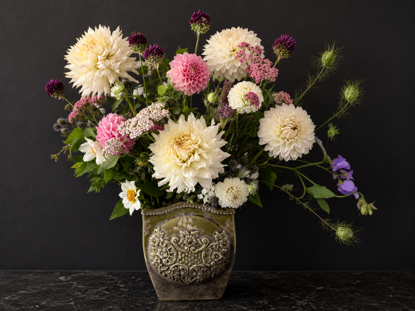 Floral arrangement in an ornate vase on a dark background