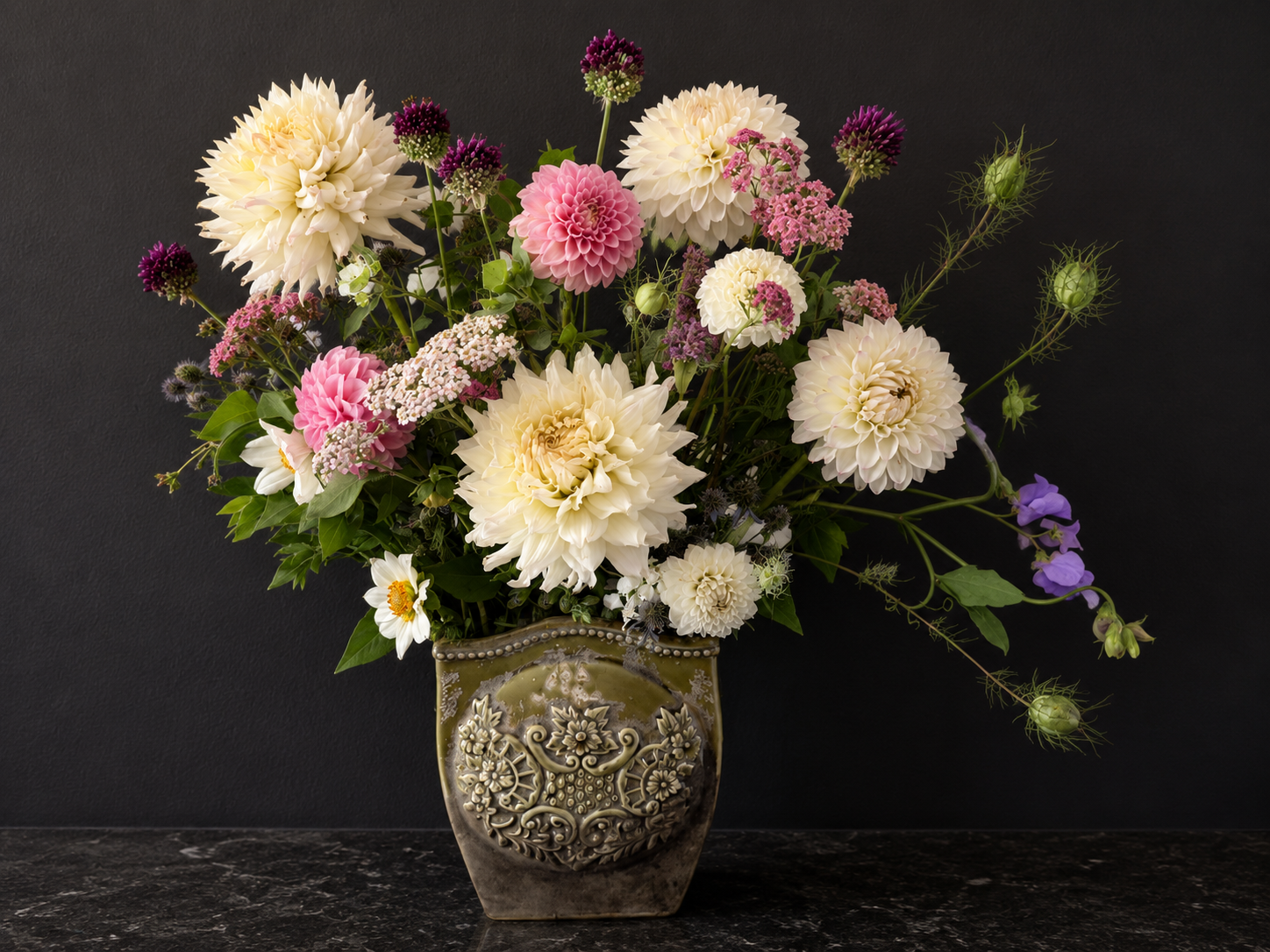 Floral arrangement in an ornate vase on a dark background